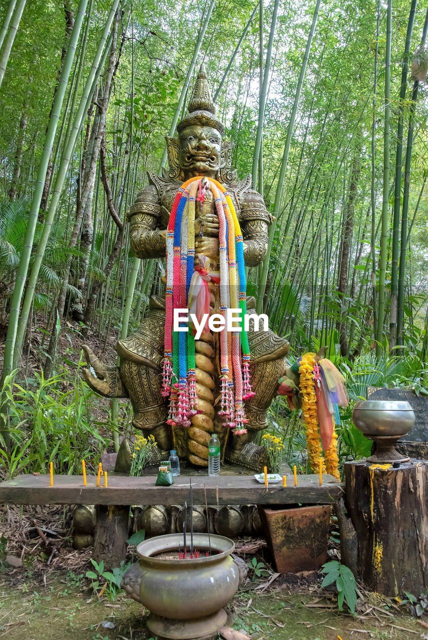 Statue of buddha against trees in thailand