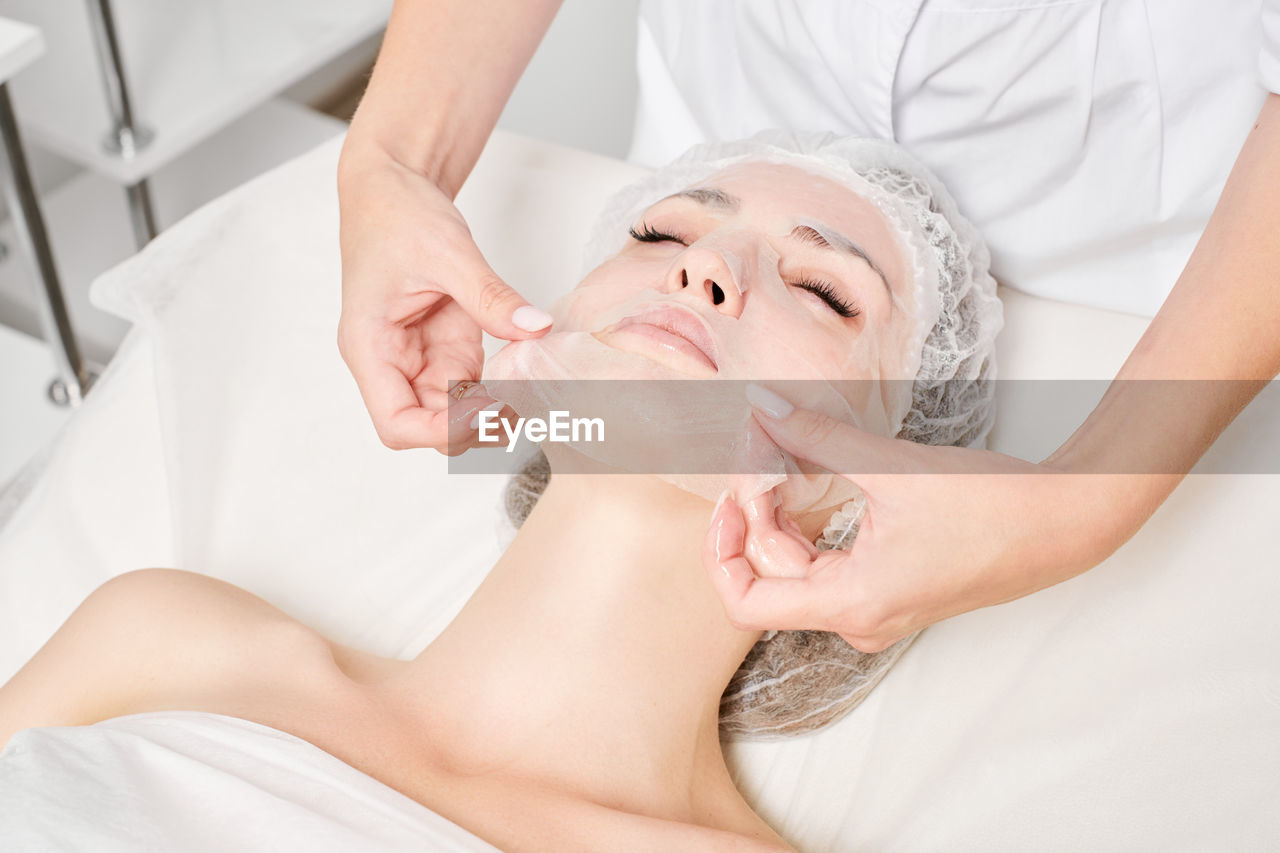 women, beauty spa, adult, body care, relaxation, human face, spa treatment, wellbeing, lying down, beauty treatment, health spa, two people, skin, indoors, young adult, healthcare and medicine, female, skin care, human skin, lifestyles, person, eyes closed, facial mask - beauty product, lying on back, massaging, patient, hand, bed, towel, food, tranquility, alternative therapy, portrait, care, human head, white, applying, hygiene, medicine, exfoliation, spa, beauty product, nose, body care and beauty, food and drink, domestic room