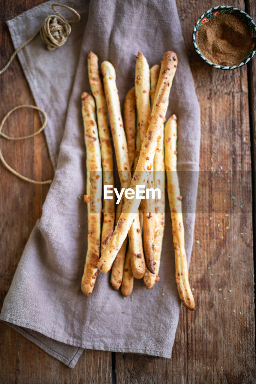 Grissini - italian bread sticks with dried herbs on a wooden background.