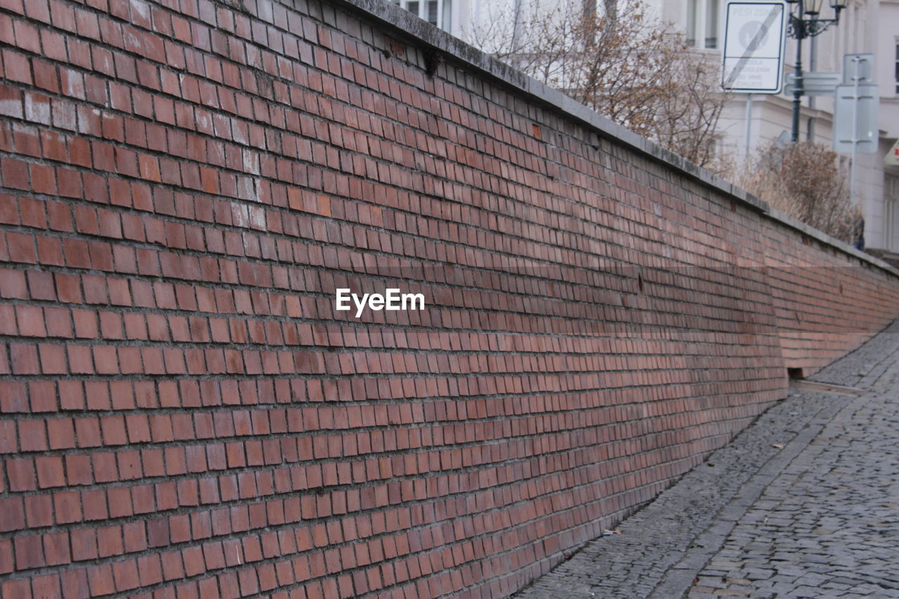 wall, architecture, built structure, brickwork, building exterior, brick, roof, day, wall - building feature, brick wall, outdoor structure, no people, road surface, facade, city, fence, wood, building, outdoors, pattern, footpath, street, nature, line, iron