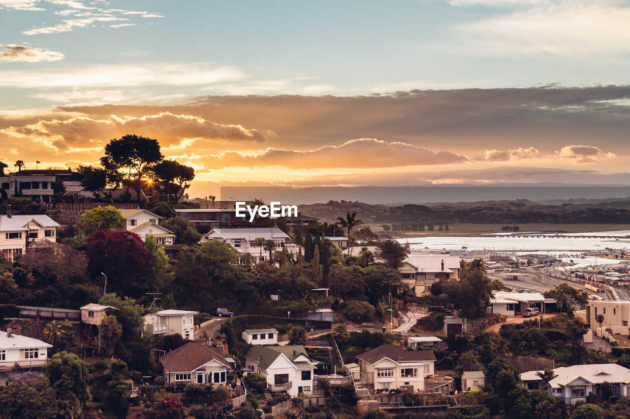 High angle view of townscape against cloudy sky at sunset