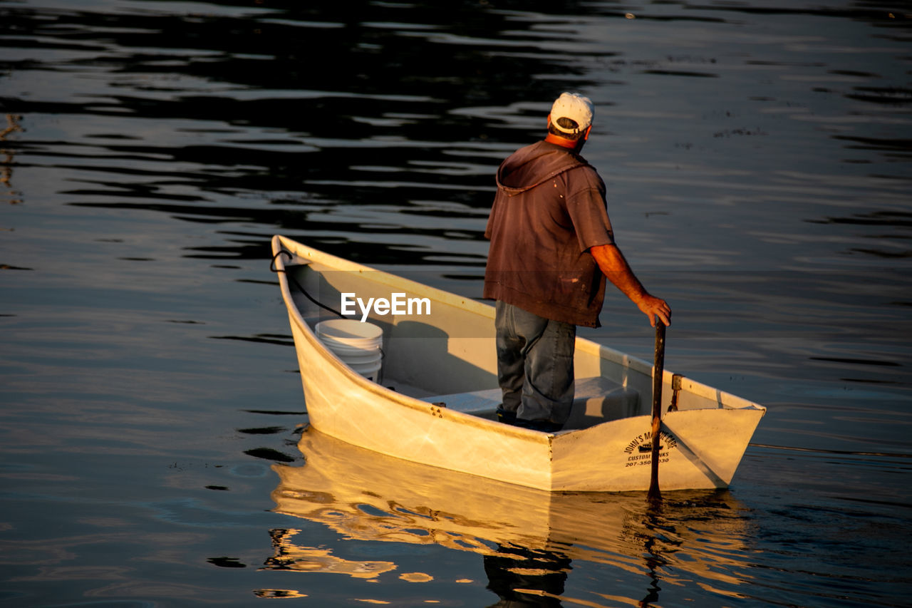 Rear view of man sailing boat in lake