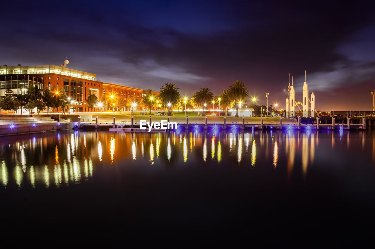 Illuminated buildings by river against sky at night geelong waterfront