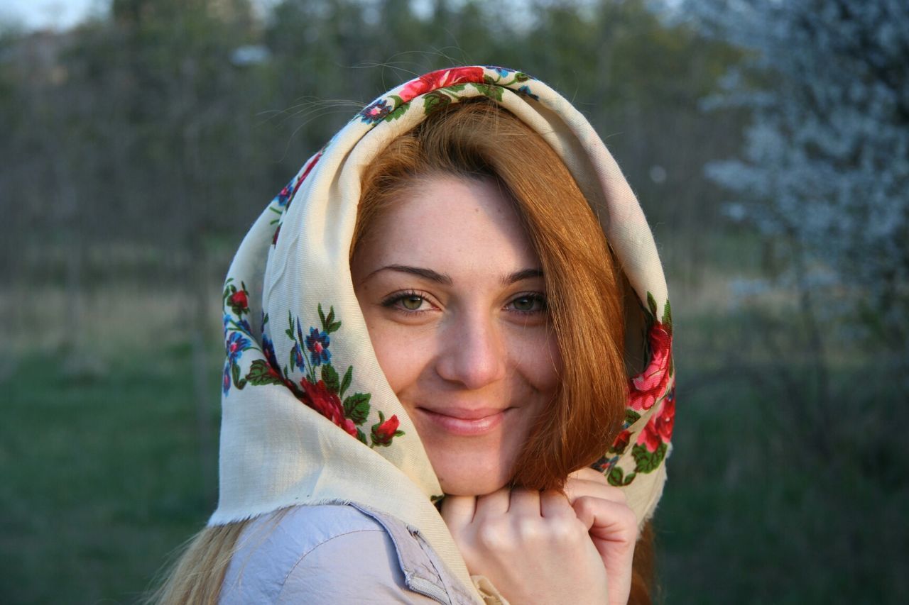 Portrait of beautiful woman in headscarf on field in morning