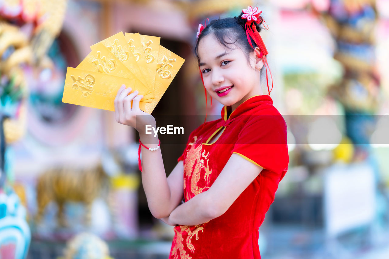 Portrait of smiling girl holding envelopes