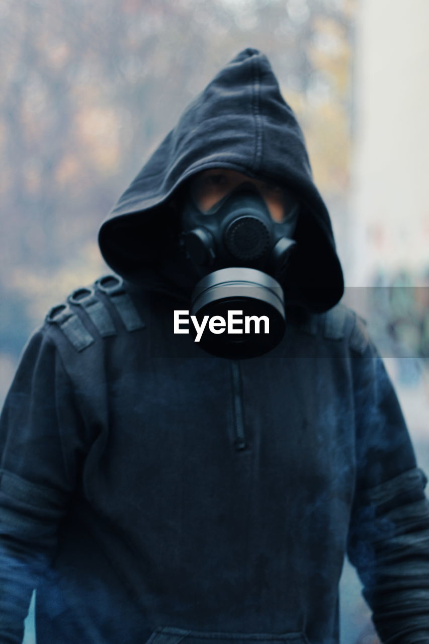 Man wearing gas mask standing outdoors 