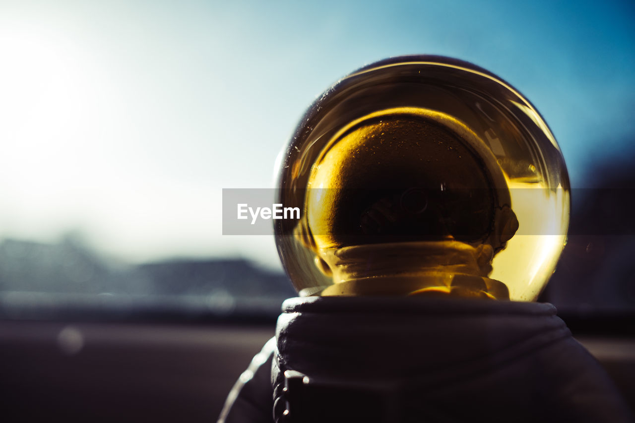 Golden astronaut helmet against blue sky