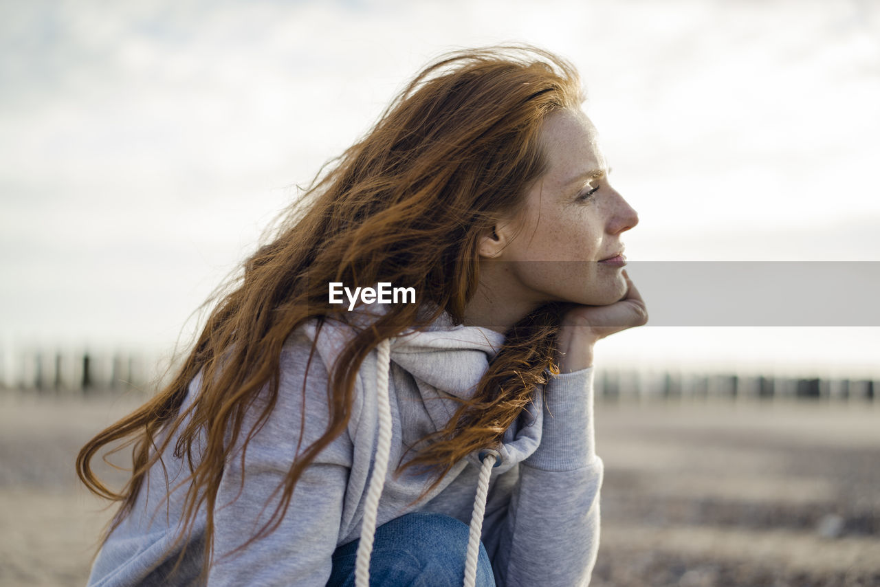 Redheaded woman enjoying fresh air at the beach