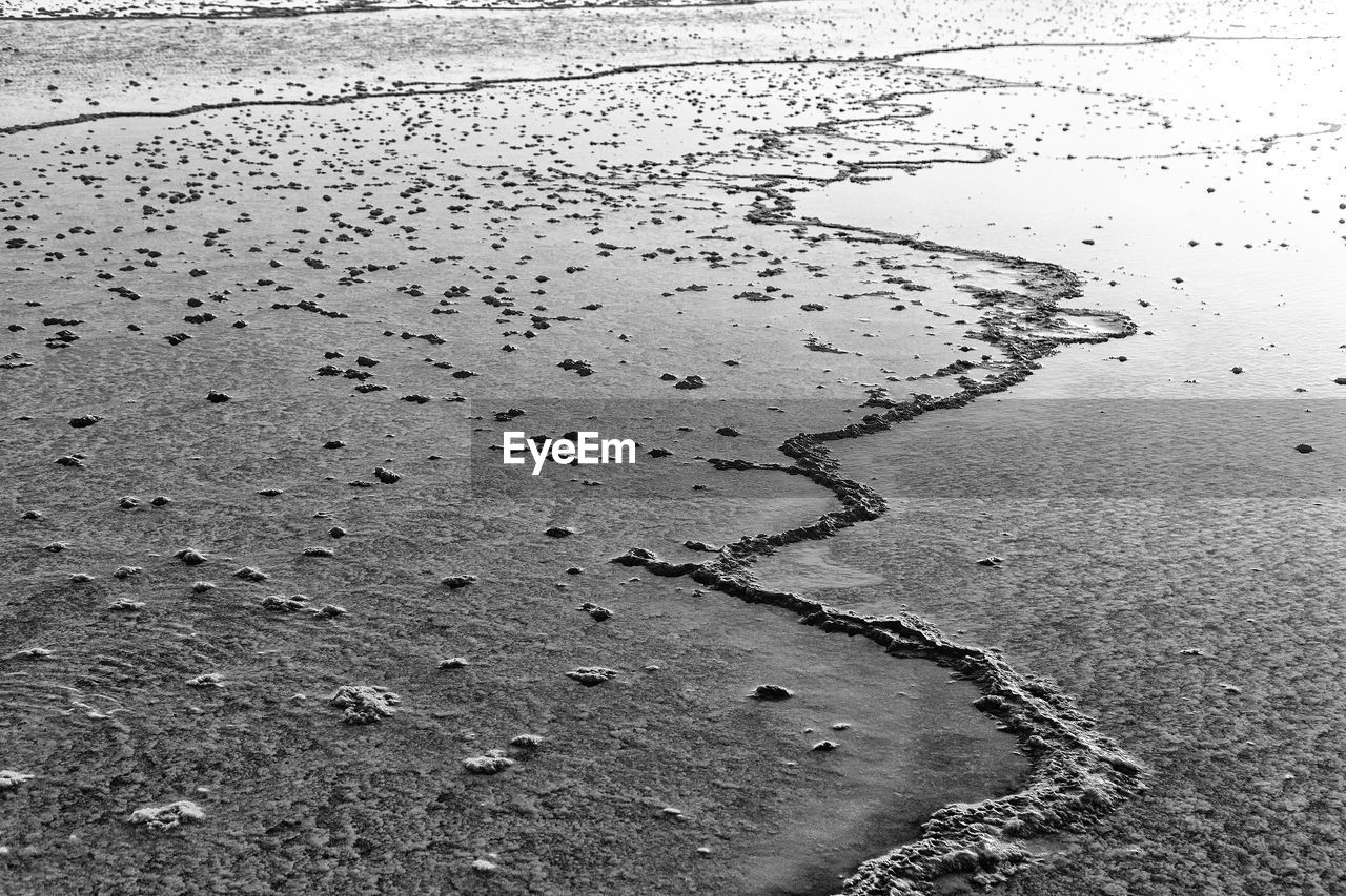 HIGH ANGLE VIEW OF WATER ON BEACH