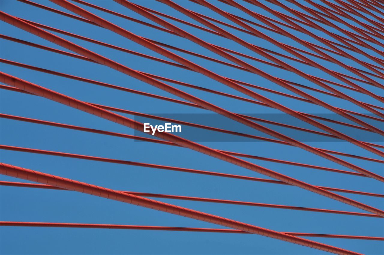 Low angle view of suspension bridge against clear blue sky