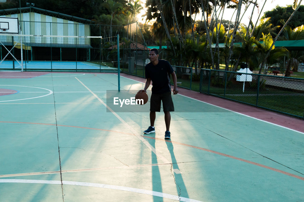 Full length of man playing basketball