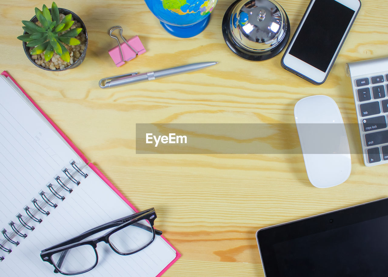 HIGH ANGLE VIEW OF EYEGLASSES AND BOOK ON TABLE