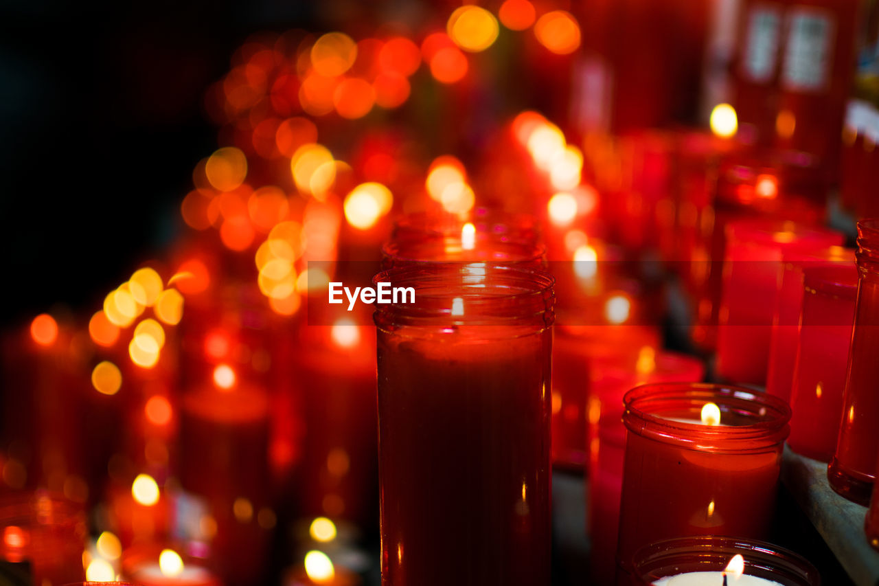 Close-up of red illuminated candles on table