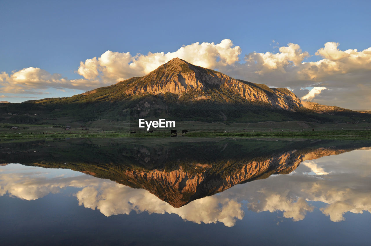 Scenic view of lake by mountain against sky