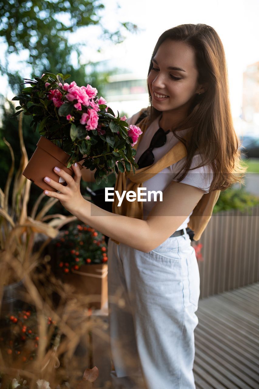 portrait of smiling young woman holding bouquet