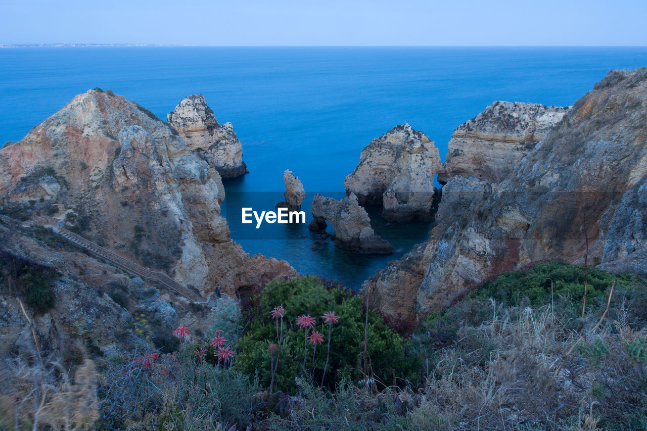 Panoramic view of rocks and sea against sky