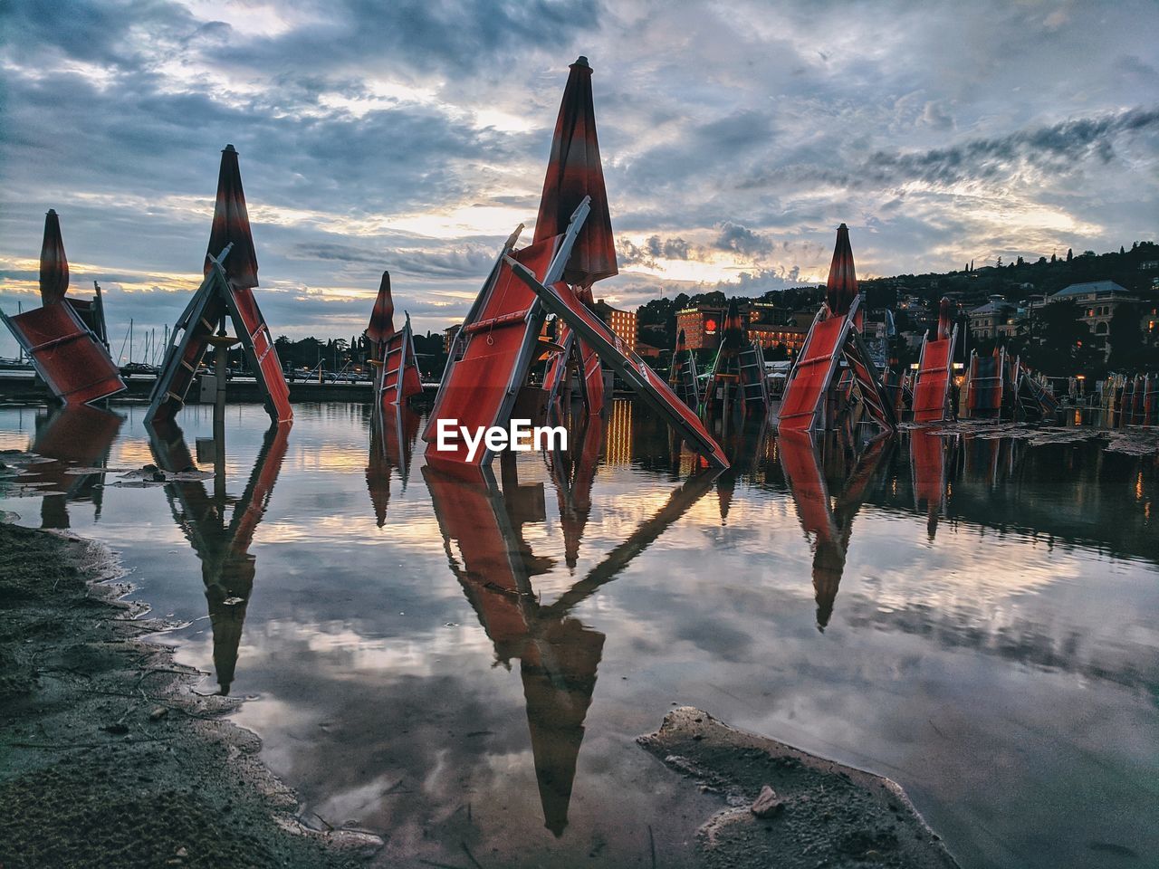 WOODEN POSTS IN LAKE AGAINST SKY