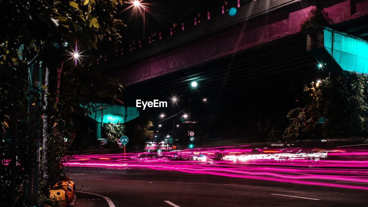 ILLUMINATED LIGHT TRAILS ON ROAD AT NIGHT