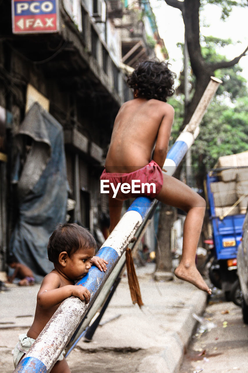 REAR VIEW OF MEN WORKING IN TRADITIONAL CLOTHING