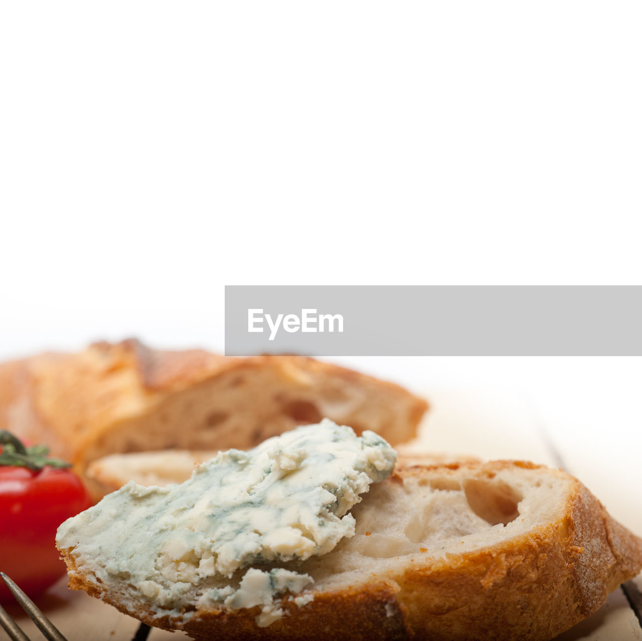 Close-up of cream cheese on bread against white background