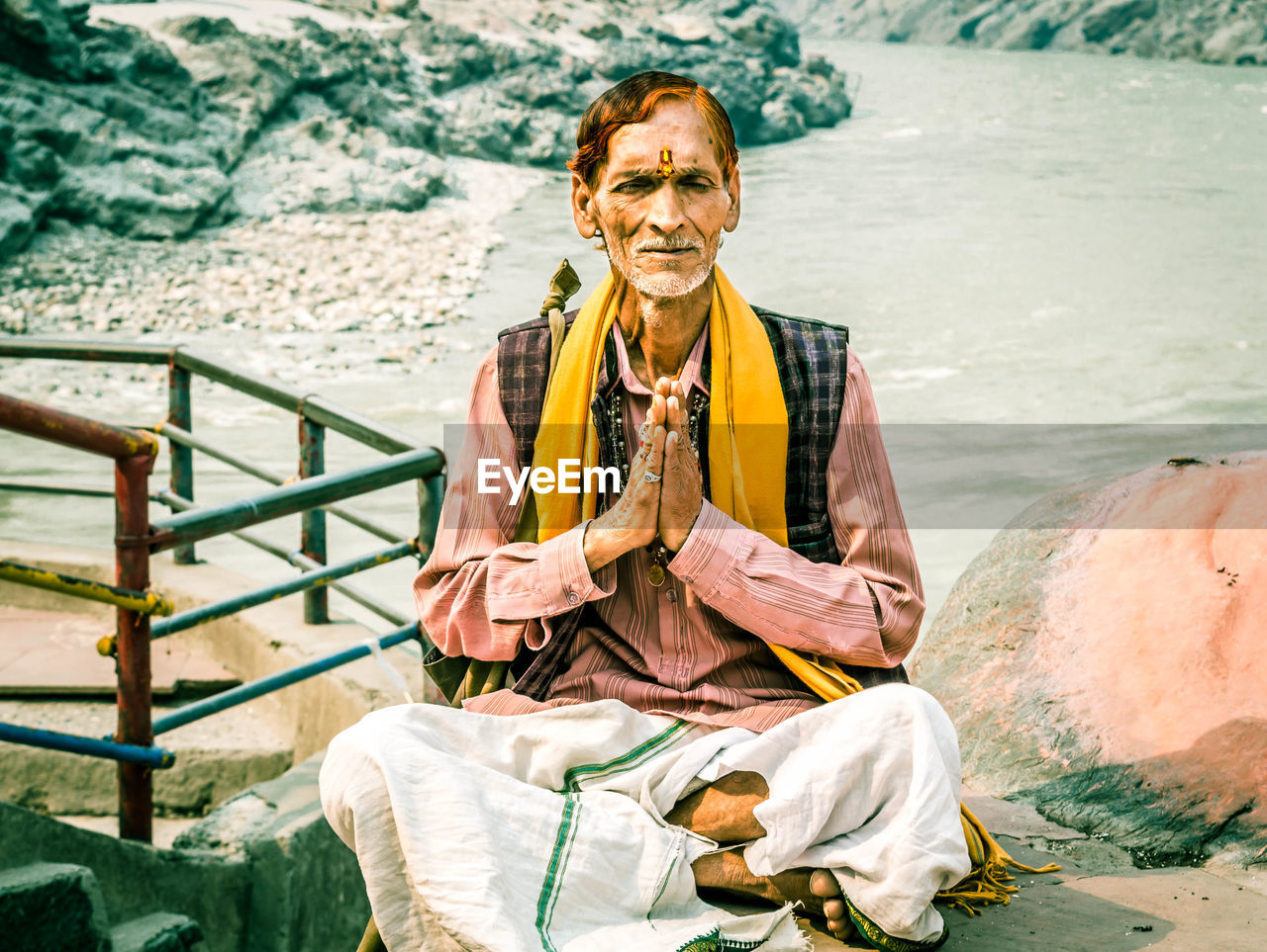 PORTRAIT OF HAPPY MAN SITTING ON BEACH