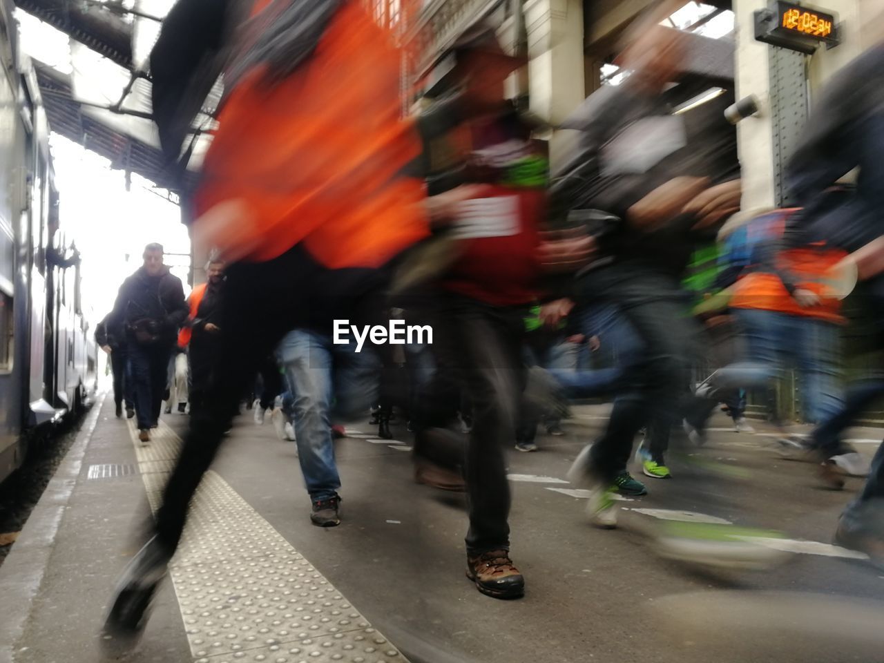 Blurred motion of people running at railroad station platform