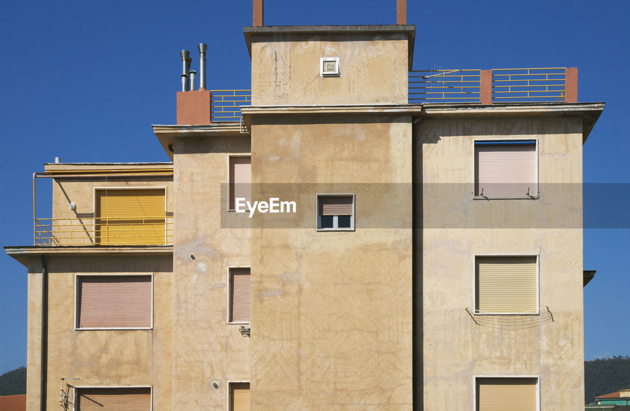 LOW ANGLE VIEW OF BUILDING AGAINST CLEAR BLUE SKY