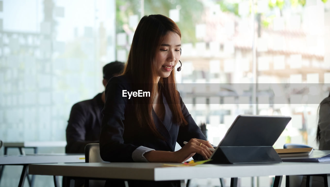 Smiling businesswoman using digital tablet at office