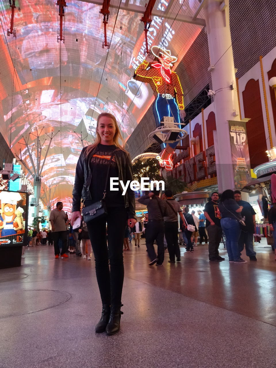 PORTRAIT OF WOMAN ON ILLUMINATED CITY STREET