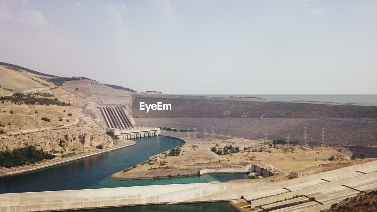 HIGH ANGLE VIEW OF DAM ON SHORE AGAINST SKY