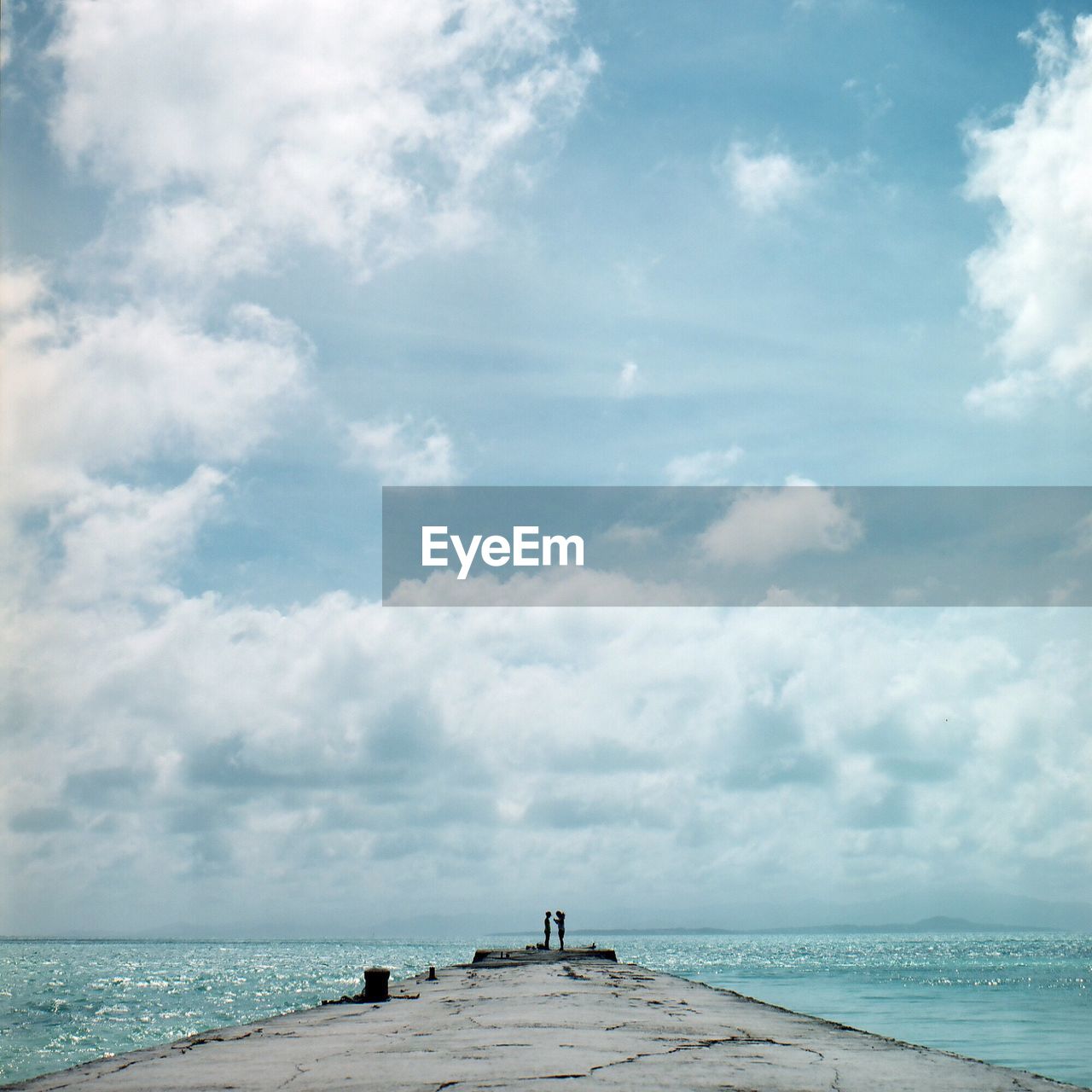 Scenic view of pier on sea against cloudy sky