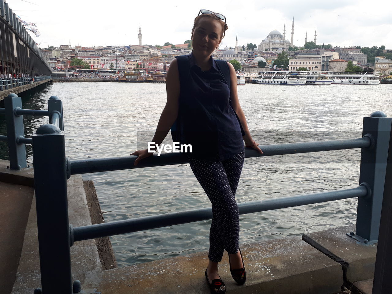 Woman standing against river in city