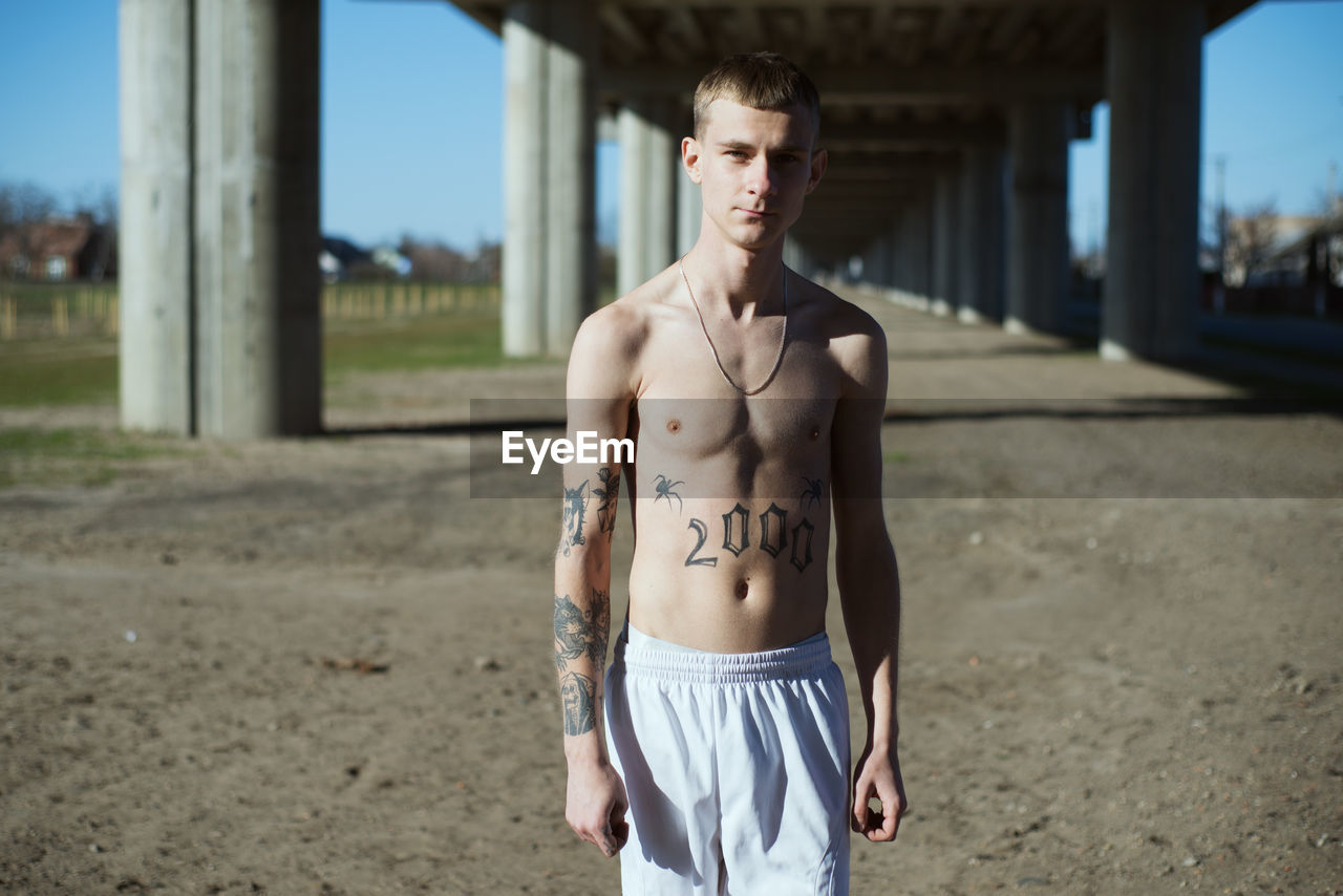 Portrait of shirtless young man outdoors