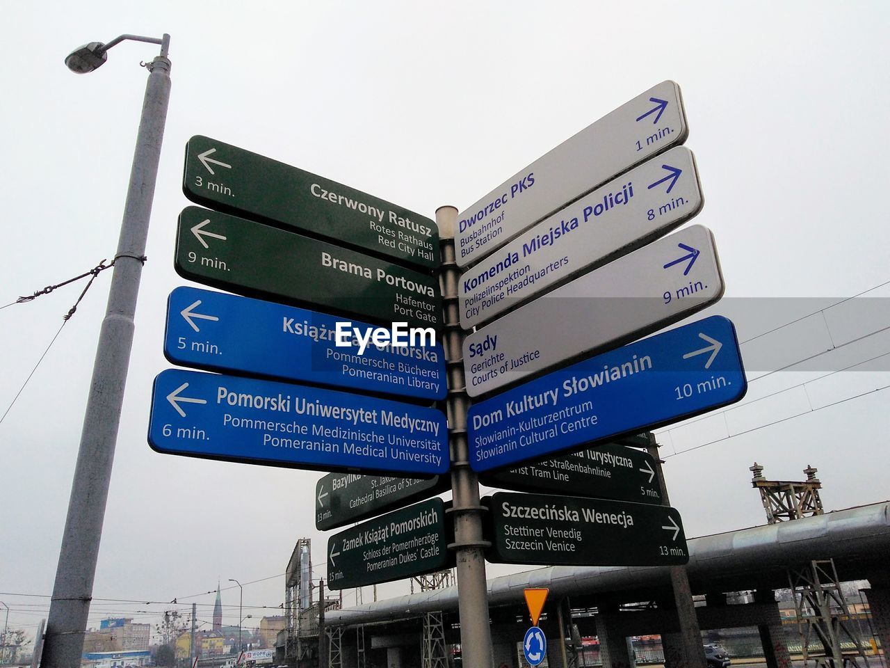 LOW ANGLE VIEW OF ROAD SIGN AGAINST SKY IN CITY