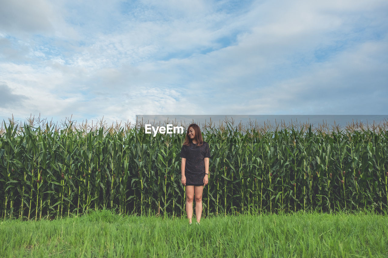 Woman standing on field against sky