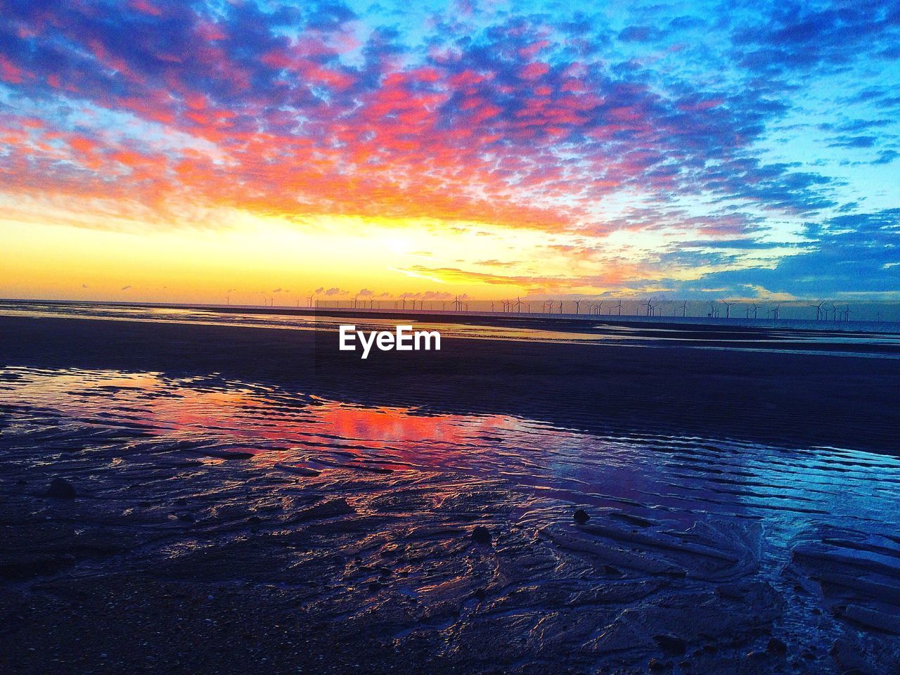 VIEW OF BEACH AGAINST CLOUDY SKY