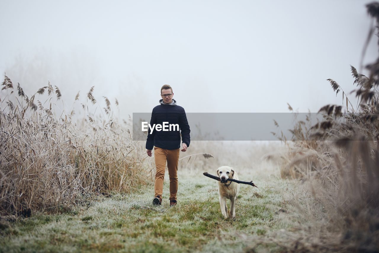 Full length of man with dog walking on land