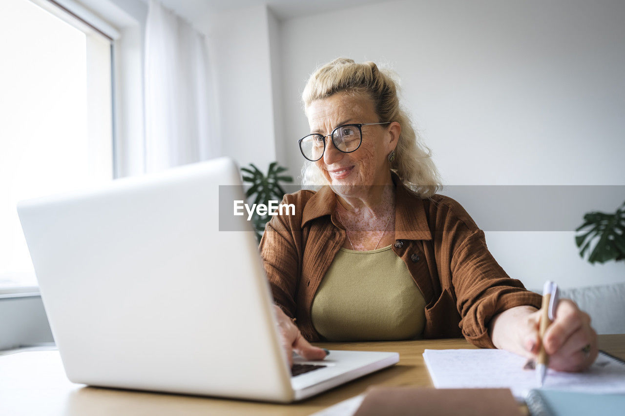 Smiling businesswoman with vitiligo skin working at home office