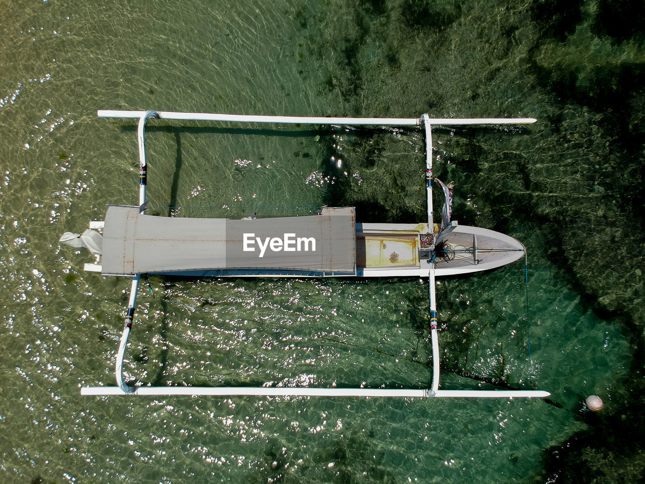 Wooden outrigger boat from directly above.