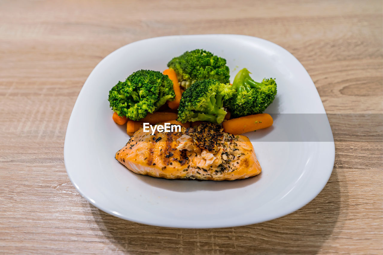 Grilled salmon and steamed veggies served on a plate.