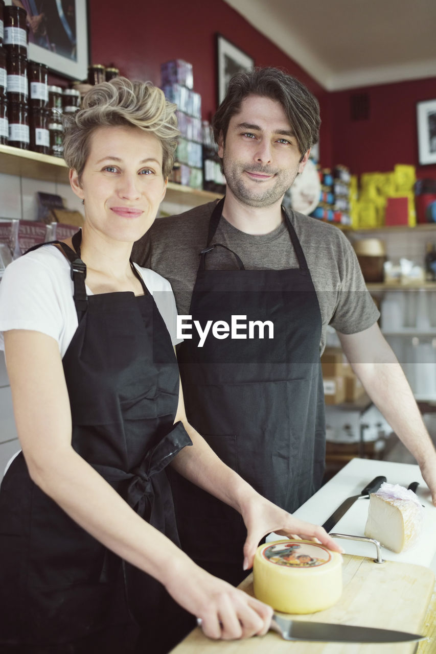 Portrait of confident workers at counter in supermarket