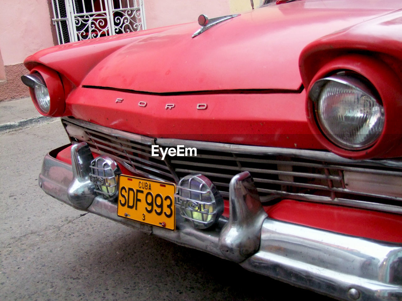 CLOSE-UP OF RED CAR ON ROAD