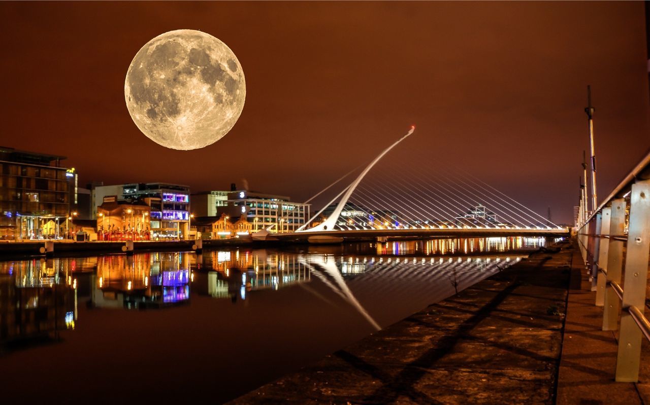 Full moon over illuminated city