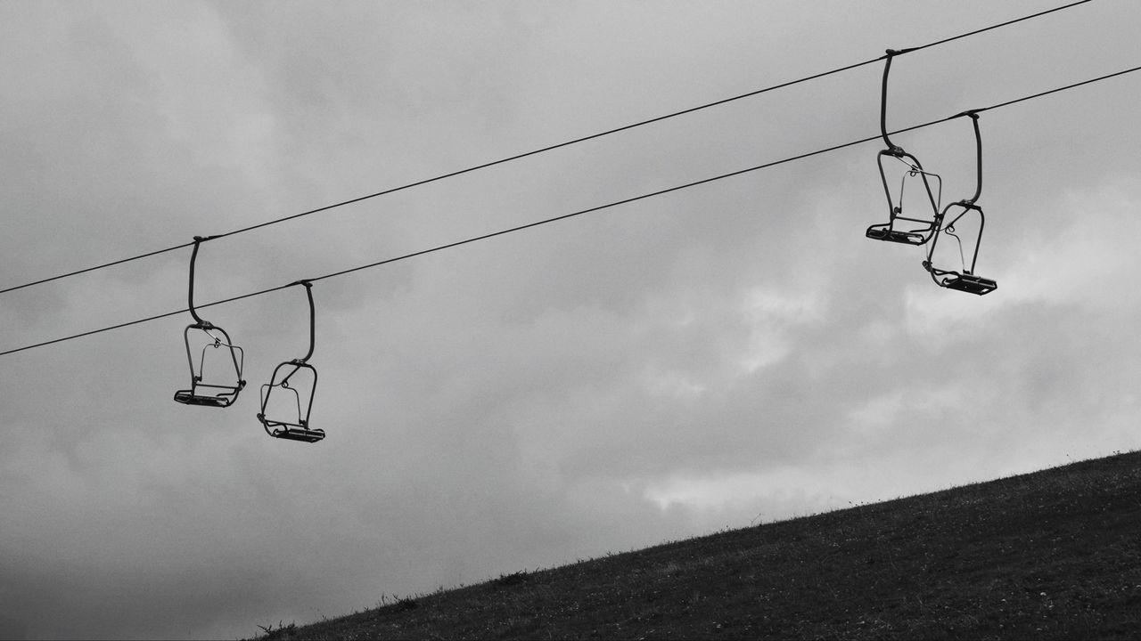 Low angle view of overhead cable cars against the sky