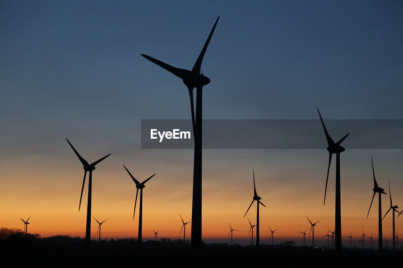WIND TURBINES ON FIELD AGAINST SKY DURING SUNSET