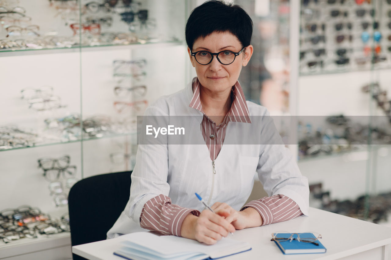 Portrait of ophthalmologist sitting on table