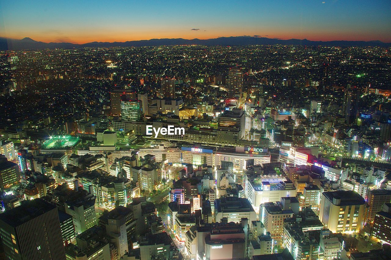 High angle view of illuminated cityscape of ikebukuro, tokyo against sky during sunset