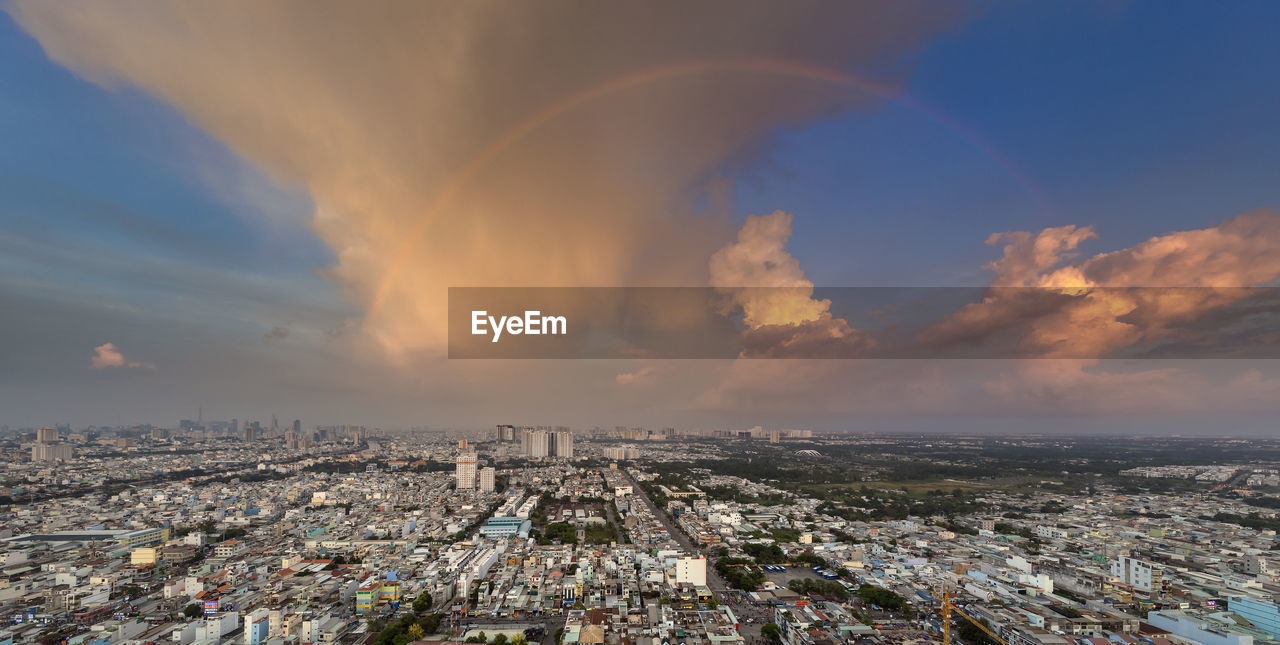 AERIAL VIEW OF RAINBOW OVER CITY AGAINST SKY