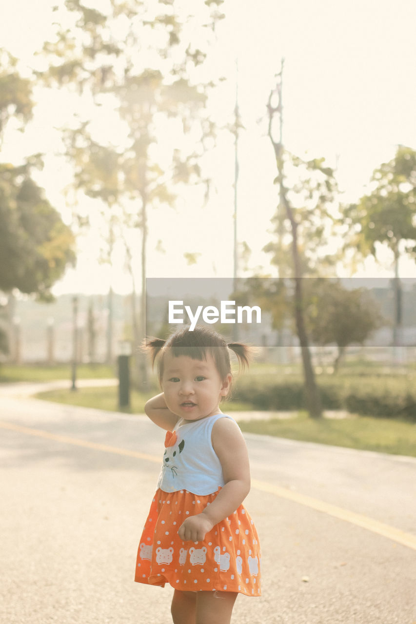 Portrait of cute girl standing on road