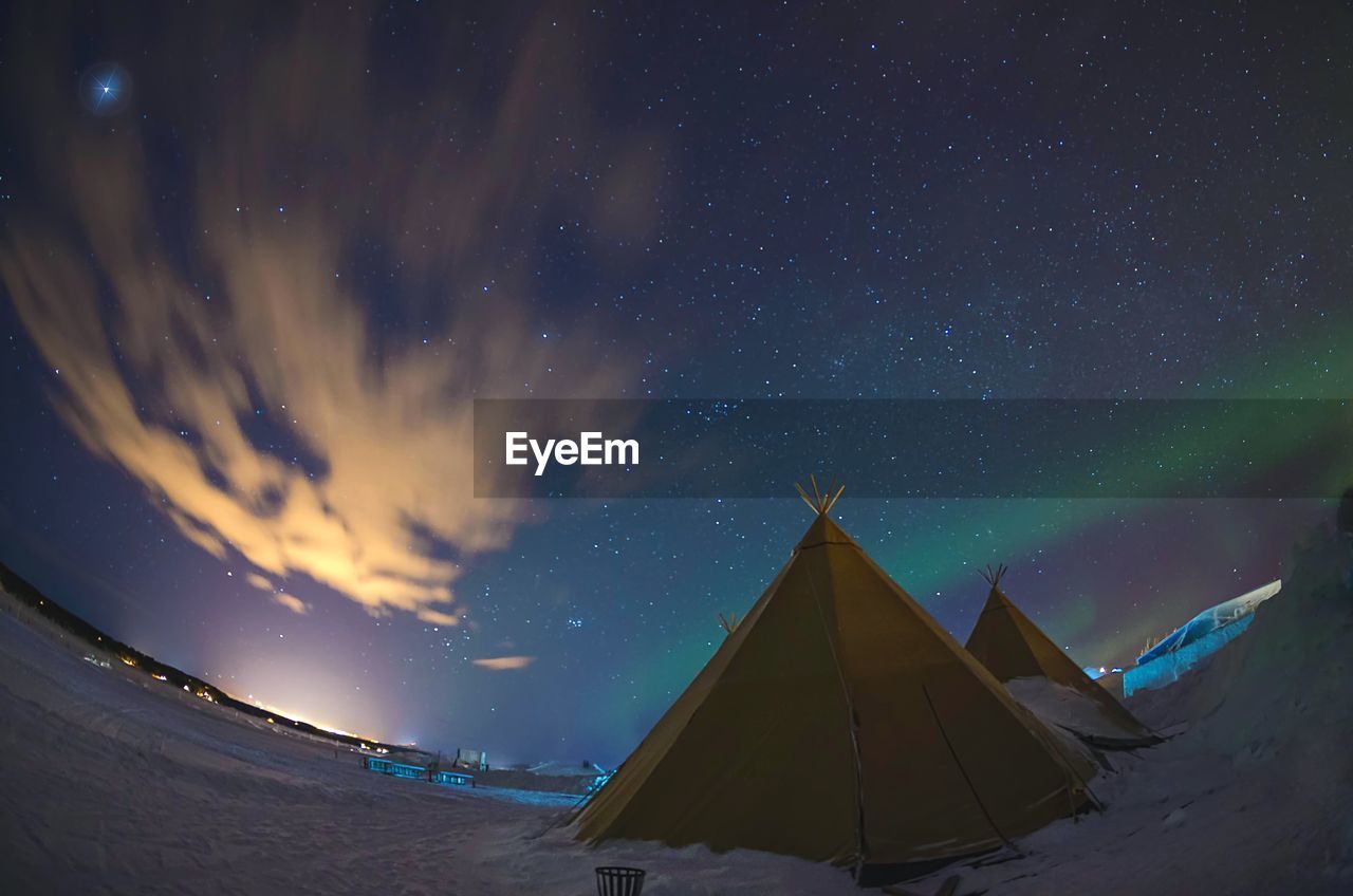 Low angle view of tents on landscape against sky